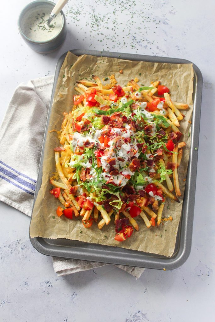French fries loaded with melted cheese, lettuce, tomato, crispy bacon bites and ranch dressing. 