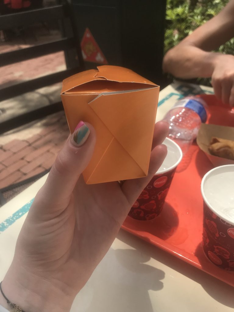 Small orange takeaway style box showing how fried rice is served as a snack at Yak and Yeti in Disney's Animal Kingdom