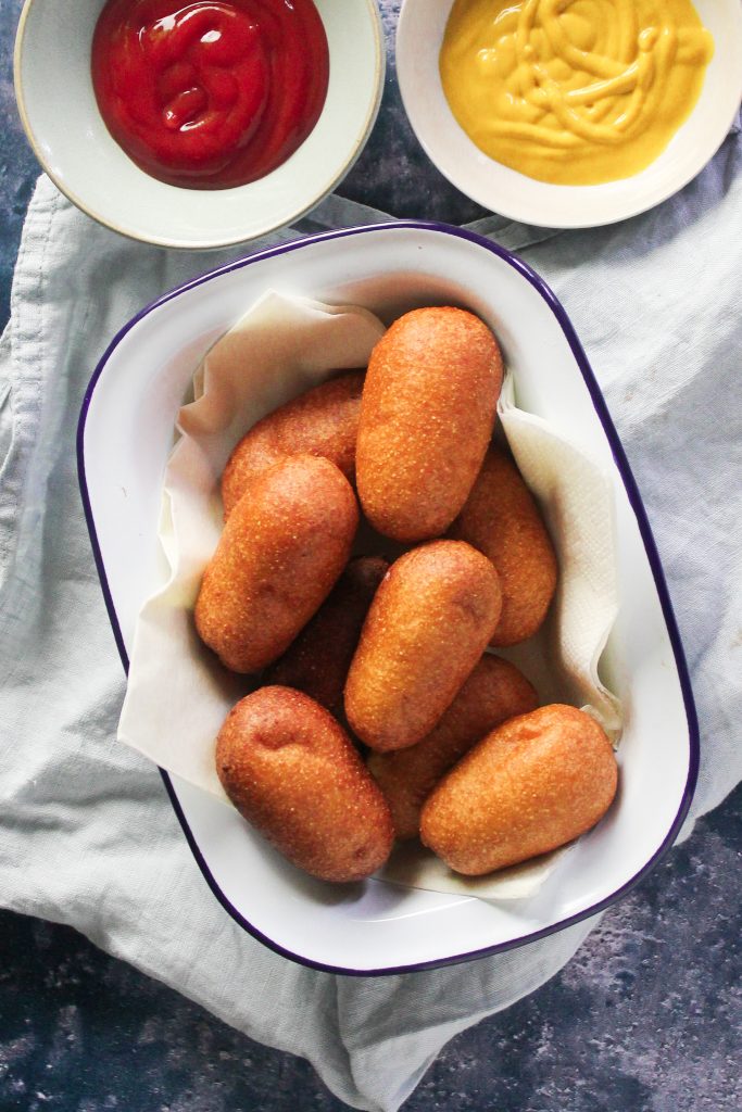 Close up of mini corn dog nuggets in a white bowl. 